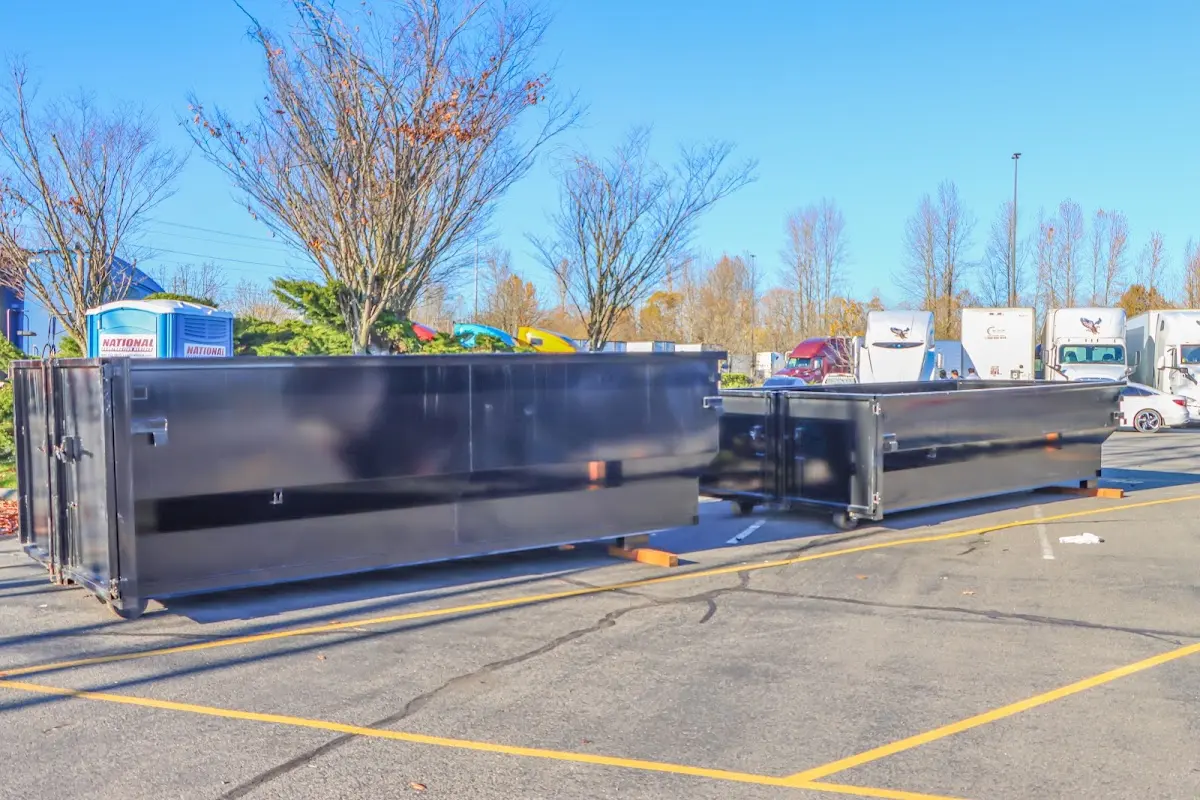 Professional dumpster rental service with roll-off container on residential driveway in Laconia